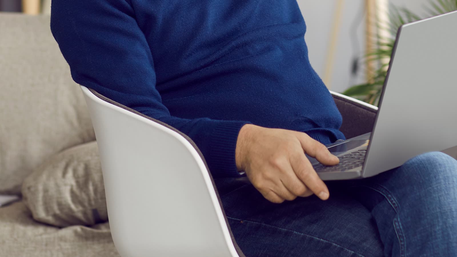 A person uses a laptop while seated at home.