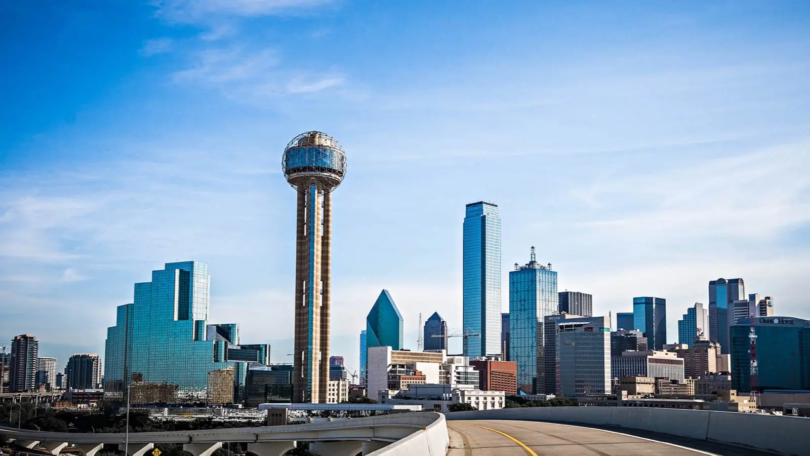 Downtown Dallas skyline at dusk with Reunion Tower lit against a purple sky