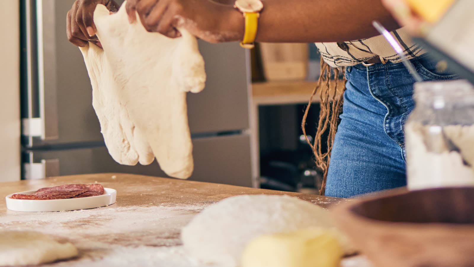Hands prepare food on a kitchen counter.