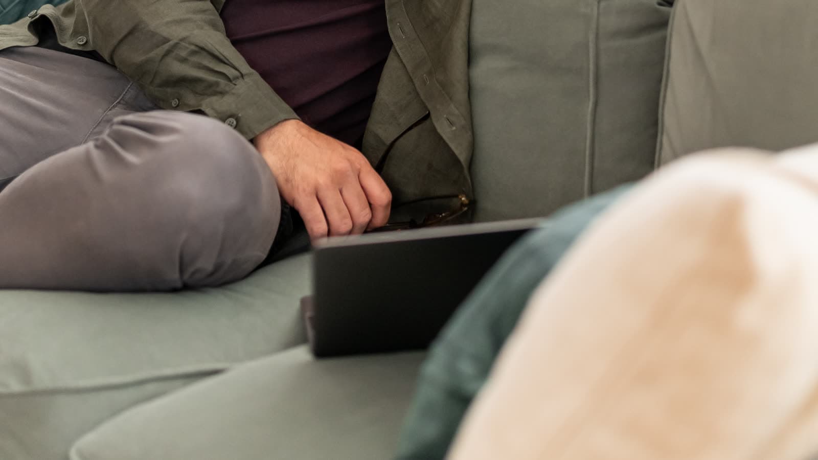 Cropped views of two seated people with a laptop between them.