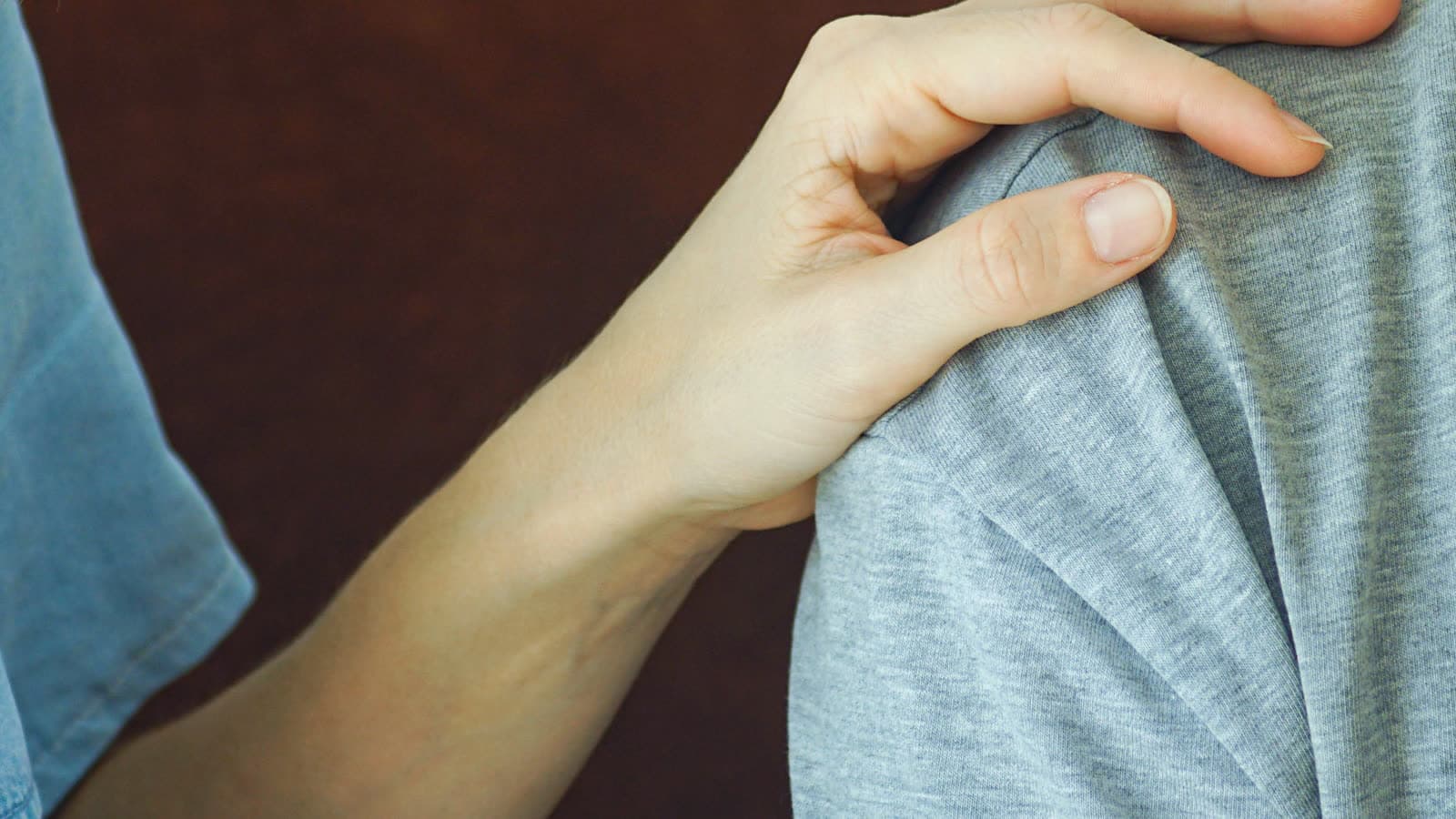 A hand rests on another person's shoulder.